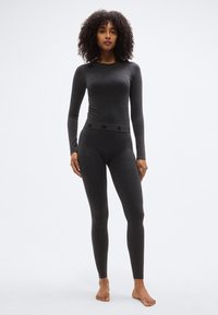 Γκρι μακρυμάνικη μπλούζα και ανταποκρινόμενο κολάν, εφαρμοστό σχέδιο, απαλό υλικό, με ζώνη μέσης με επωνυμία που διαθέτει μικρό μοτίβο λογότυπου.