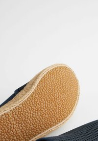 Marine slip-on sko med en tekstureret mesh-overdel, naturlig jute mellemsål og en gummiydersål med en pebret mønster for bedre greb.