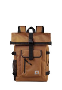 Brązowy plecak z materiału, z zamknięciem typu roll-top, czarnymi paskami, przednią kieszenią, boczną kieszonką z siateczki oraz małą kieszonką na zamek.