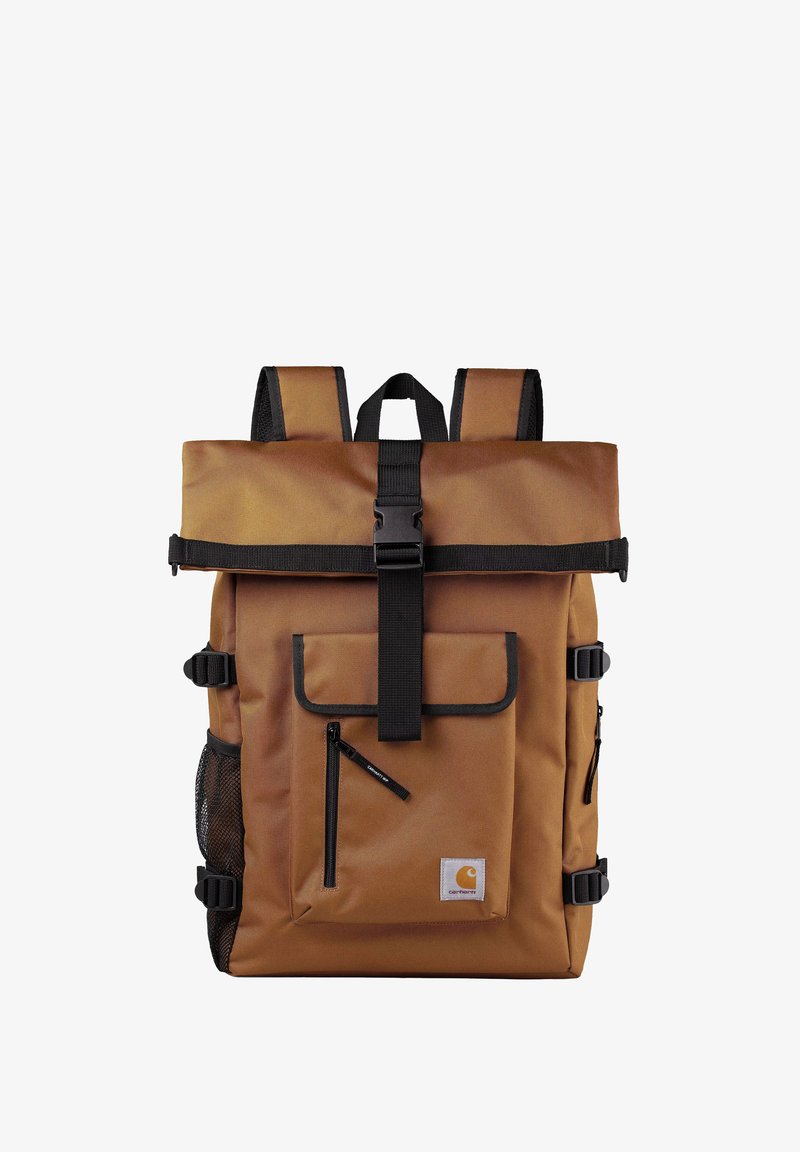 Brązowy plecak z materiału, z zamknięciem typu roll-top, czarnymi paskami, przednią kieszenią, boczną kieszonką z siateczki oraz małą kieszonką na zamek.