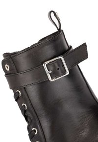 Čierne kožené čižmy s textúrovaným povrchom, viazaním, výškou po členok a detailmi v podobe striebornej pracky. Obsahujú kovové očká na šnúrky.