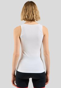 Witte mouwloze sportshirt met een mesh-structuur, een aansluitend ontwerp en een ronde halslijn, gecombineerd met zwarte shorts met roze accenten.
