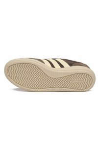 Baskets marron avec des accents crème. Présente une semelle en caoutchouc texturée avec un motif en zigzag et trois bandes horizontales sur le côté.