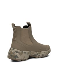 Stivale beige alla caviglia con pannelli laterali elastici, retro testurizzato e suola con motivo mimetico. Realizzato in materiali sintetici per garantire durata.