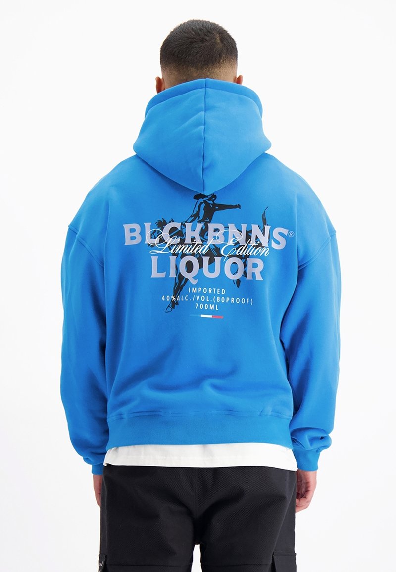 Blauwe hoodie met een grote graphic op de achterkant met tekst en silhouetten. Zachte katoenen stof en een relaxte pasvorm, met een ruime capuchon.