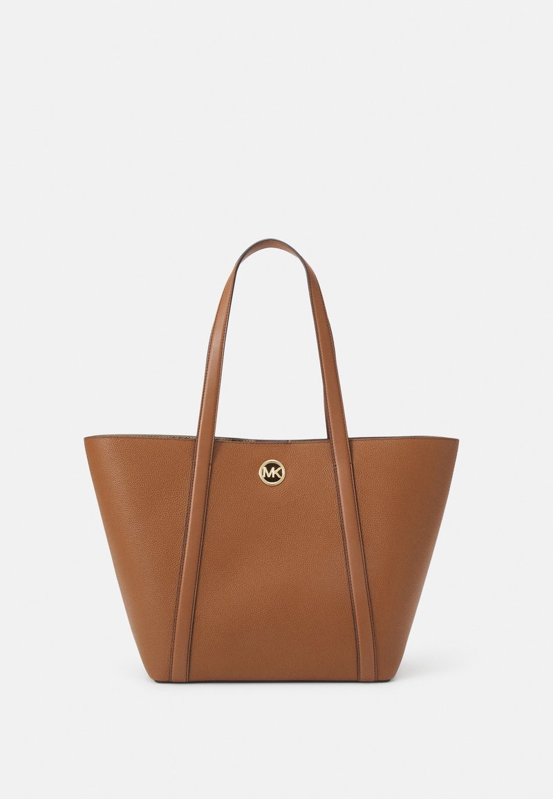 Sac cabas en cuir marron avec deux longues anses et un emblème circulaire en or au centre de l'avant.