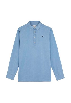 Camisa de manga larga de un suave tejido chambray en azul claro. Presenta una tapeta con botones, cuello clásico y un pequeño logo bordado en el pecho.