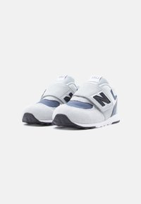 Γκρι και ναυτικό αθλητικά παπούτσια με υλικά από σουέντ και δίχτυ, λουράκι με βέλκρο, στρογγυλεμένη μύτη, λευκή μεσαία σόλα και μαύρη λαστιχένια εξωτερική σόλα.