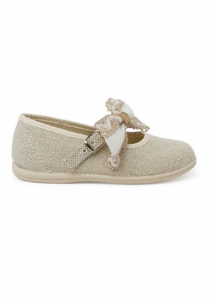 Chaussure en tissu beige avec un bout rond, une semelle plate et une boucle sur le côté. Décorée d'un nœud texturé dans une couleur plus claire. Matériel doux et tissé.
