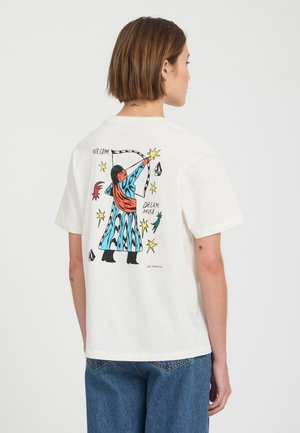 Personne portant un t-shirt blanc avec un graphique coloré d'un archer entouré d'étoiles et les mots "Volcom" et "Dream Muse" au dos.