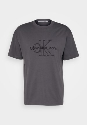 Graues Baumwoll-T-Shirt mit kurzen Ärmeln und Rundhalsauschnitt, mit einem schwarzen Grafikdesign von "CK" und dem Text "Calvin Klein Jeans".