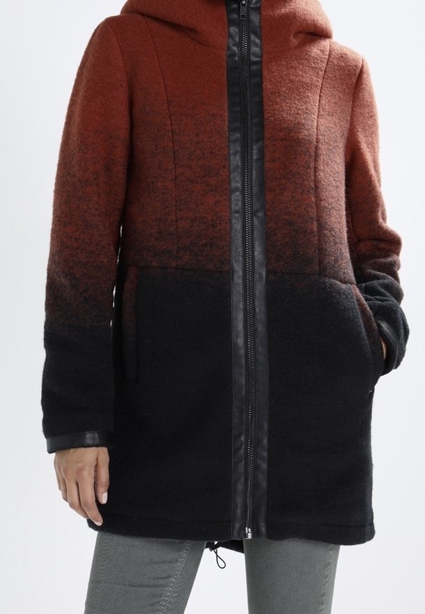 Manteau en mélange de laine présentant un dégradé allant de l'orange brûlé au noir, avec une fermeture éclair frontale, une capuche et des poches latérales. Surface texturée avec des accents en cuir.