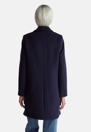 Cappotto in lana navy con taglio dritto, maniche lunghe e colletto a revers, caratterizzato da una texture liscia e un design minimale sul retro.