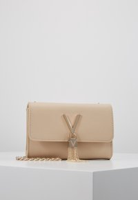 Borsa a mano in pelle sintetica beige con chiusura a patta, dettagli in oro, logo a V e nappina a catena. Dotata di tracolla a catena dorata.