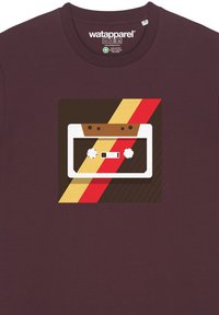 Bordeaux t-shirt met een afbeelding van een cassettebandje met crème- en bruine accenten, omringd door gedurfde diagonale strepen in rood, geel en bruin.