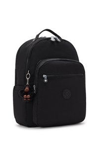Mochila de nailon negra con un bolsillo frontal, dos cremalleras, una superficie texturizada y un llavero en forma de mono colgado de una cremallera.