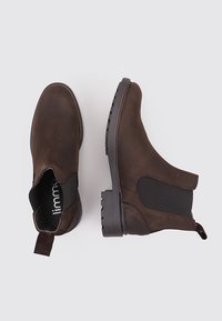 Bottines en cuir marron avec des panneaux élastiques latéraux, dotées d'une languette et d'une semelle en caoutchouc texturée pour une meilleure adhérence. Design classique de bottines Chelsea.