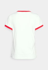 Hvid T-shirt med korte ærmer, der har rød kant ved kraven og ærmerne. Glat tekstur, afslappet pasform, enkelt design.