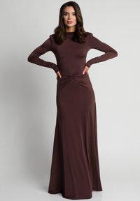 Fioletowa sukienka z długim rękawem, dopasowanym gorsetem, detalami w pasie oraz zwiewnym dołem. Gładki, elastyczny materiał o subtelnej połysku.