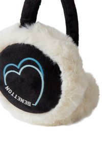 Zwarte en crèmekleurige nep bont oorkappen met een zachte textuur, voorzien van een hartlogo in blauw en wit op de zwarte stof.