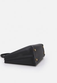 Black leather handbag with a structured, triangular shape, gold hardware accents, and a textured surface. Minimalist design with flat bottom.