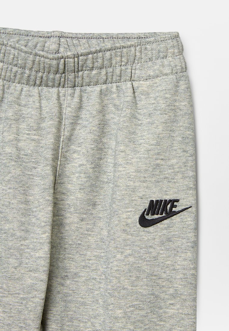 Pantalones de chándal grises hechos de una tela suave con una cintura elástica. Presenta un logo de Nike negro bordado en el lado izquierdo.