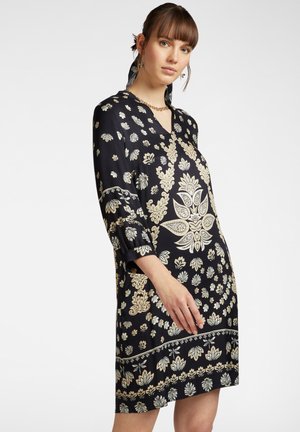 Zwarte jurk met een bloemenpatroon in roomwit en goud, V-hals, driekwart mouwen en een ontspannen pasvorm met een decoratieve zoom.