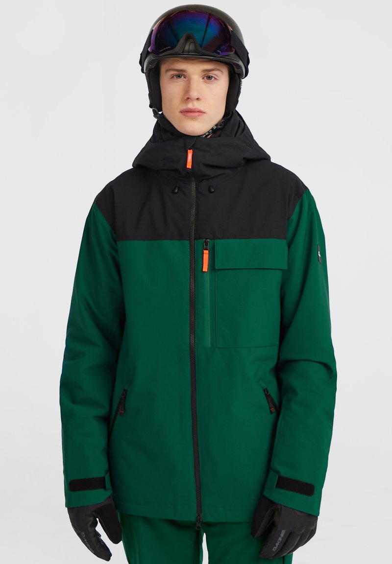 Grøn og sort isoleret skijakke med lynlåslommer, justerbar hætte og orange detaljer. Materialet ser glat og vandtæt ud.