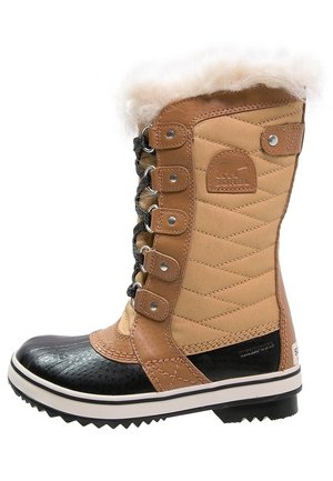 Botte haute d'hiver avec tissu matelassé couleur tabac, bout en caoutchouc noir, laçage à l'avant et bordure en fausse fourrure blanche en haut.