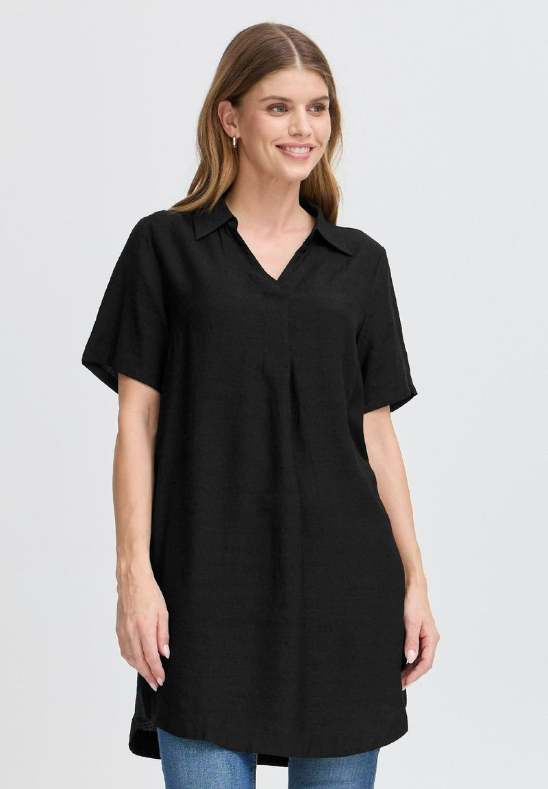 Black tunic shirt with a notch collar, short sleeves, and a loose fit. Made of textured fabric, featuring side slits for ease of movement.