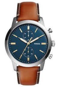 Montre Fossil pour homme avec un cadran bleu, des accents dorés et des sous-cadrans. Boîtier en acier et bracelet en cuir brun avec des coutures contrastées.