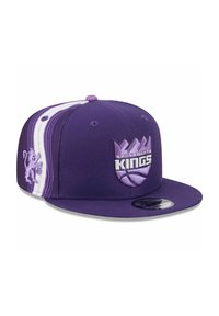 Purple flat-brim cap featuring embroidered Sacramento Kings logo, side lion graphic, and striped accents in lighter purple and white.