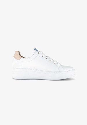 Witte lage sneaker met witte veters, dikke zool en beige suède hielstuk, zijaanzicht op een witte achtergrond.