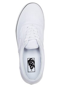 Baskets en toile blanche avec un bout rond, des lacets plats blancs et un accent de semelle en caoutchouc noir. Comprend le logo Vans sur la semelle intérieure.