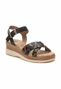 Sandalias de cuña de cuero marrón con correas de estampado de leopardo, correa ajustable en el tobillo y una suela texturizada en beige. Presentan una plantilla con efecto de madera.