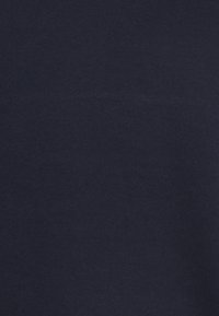 Tessuto blu navy con una superficie liscia, che mostra una struttura uniforme senza motivi o cuciture visibili. Materiale morbido e leggero.