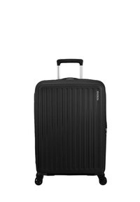 Valigia rigida nera con scanalature verticali, manico in alluminio retrattile, quattro ruote e un comparto con zip per lo stoccaggio.