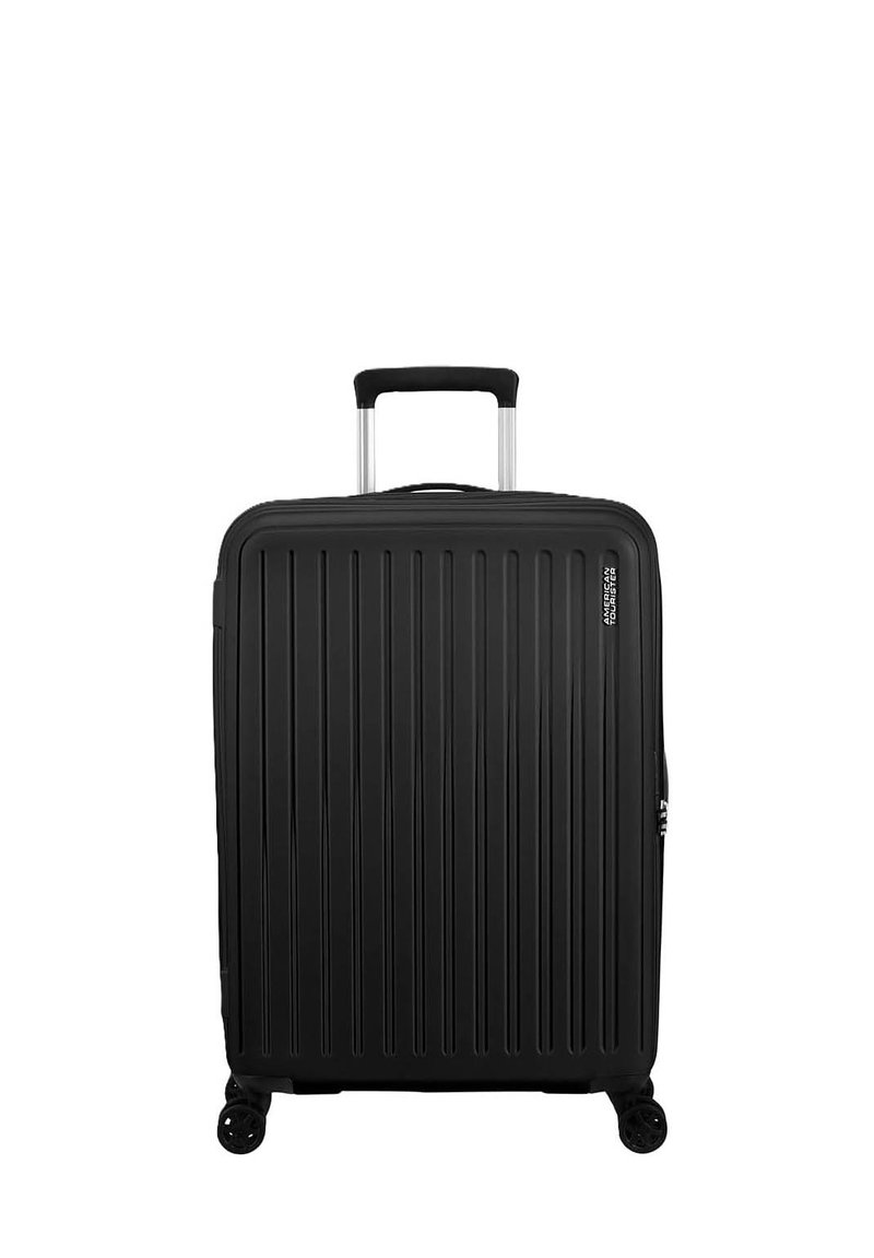 Valigia rigida nera con scanalature verticali, manico in alluminio retrattile, quattro ruote e un comparto con zip per lo stoccaggio.