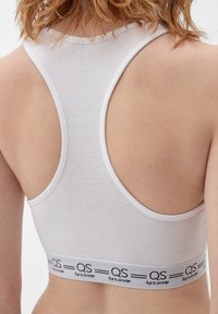 Witte sportbh met een tanktopontwerp en een brede elastische band met zwarte "QS by s.Oliver" branding, van een soepele katoenen stof.