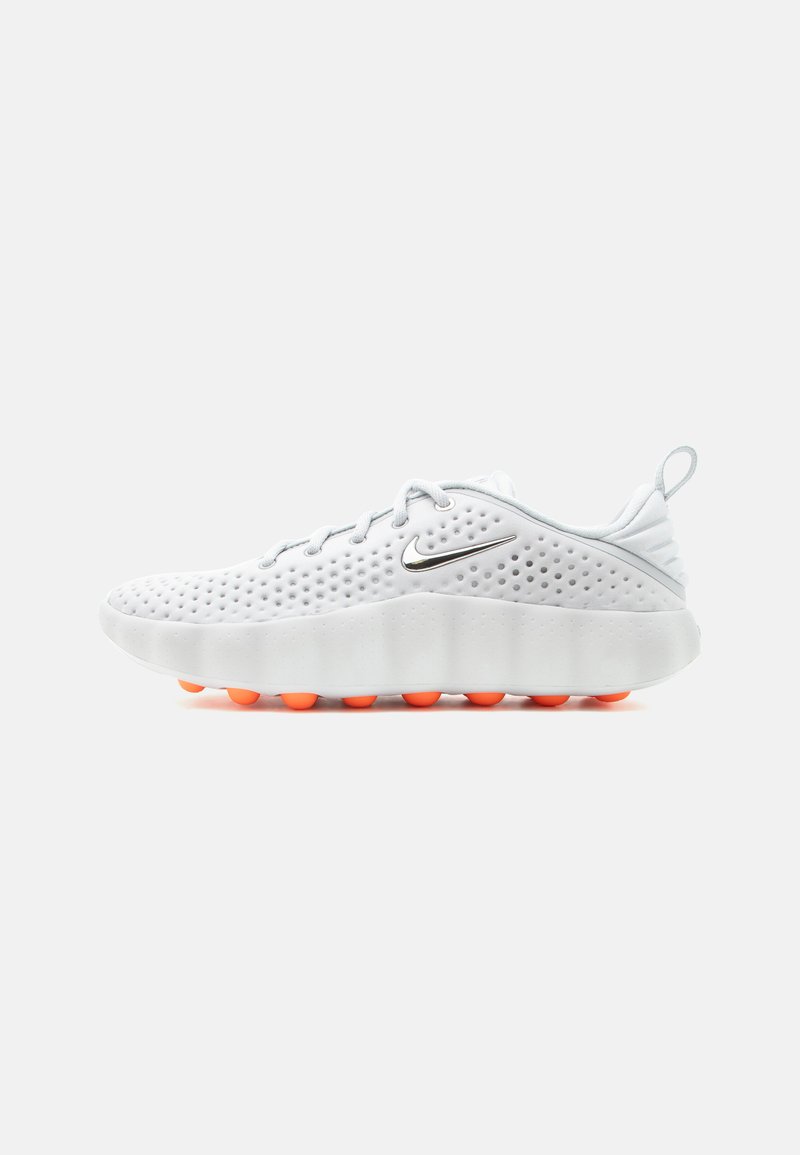 Λευκό, διάτρητο αθλητικό παπούτσι με πορτοκαλί τμήματα σόλας, κορδόνια, θηλιά στο πίσω μέρος και ασημί λογότυπο Nike στη πλευρά.