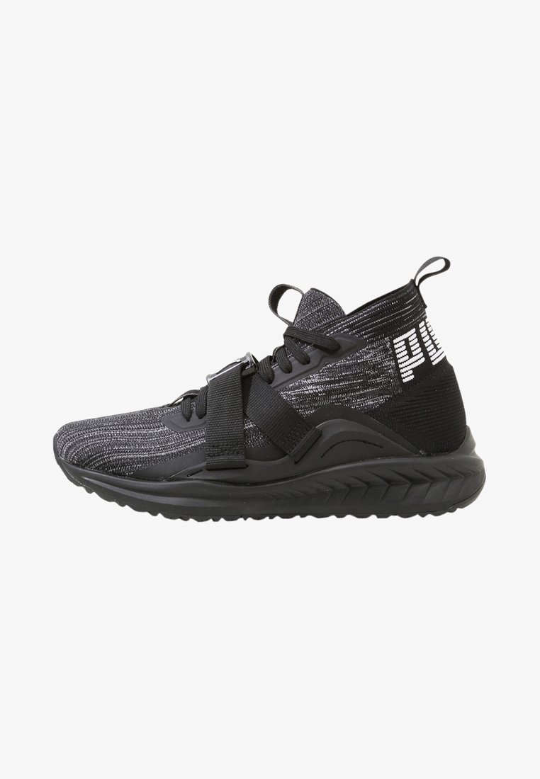 Baskets de sport noires et grises avec un texte blanc sur le talon, une semelle épaisse, des lacets et une sangle réglable sur le dessus.