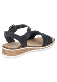 Black leather sandal with multiple straps, cork wedge sole, tan footbed, and white rubber outsole. Adjustable heel strap for fit.