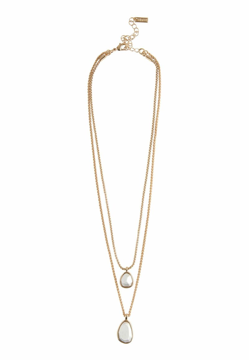 Gouden dubbele ketting met twee druppelvormige pendants, met een transparante steen ingekapseld in een slank frame.