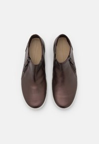 Brązowe wsuwane buty ze skóry z bocznymi zamkami, zaokrąglonym noskiem i białymi gumowymi podeszwami. Gładka faktura z minimalistycznymi detalami.