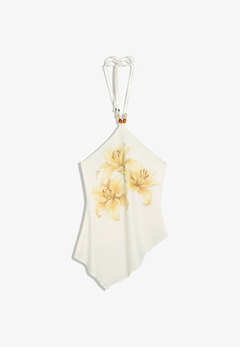 Top blanc à col halter avec un ourlet asymétrique et un imprimé floral de lys jaune au centre devant, orné de perles sur les bretelles.
