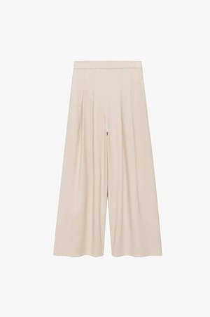 Pantaloni beige a gamba larga realizzati in tessuto morbido con una parte anteriore plissettata e vita alta, caratterizzati da una silhouette rilassata e senza chiusure visibili.