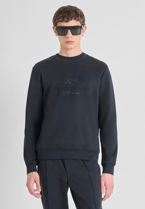 Marineblauwe sweatshirt met een ronde halslijn, voorzien van een textuur logo ontwerp in een donkerdere tint. Gecombineerd met bijpassende broek.