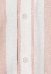 Linskjorta med horisontella ränder i ljusrosa och vitt, med rund knappstängning och subtil textur.