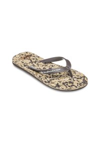 Brune flip-flop med en struktureret beige og brun mønstret sål. Gummistropper med ribbet design mødes ved tåen. Indeholder et logo.