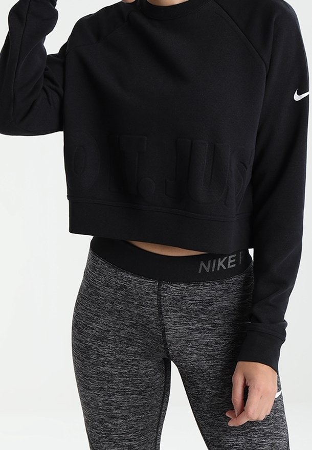 Černá krátká mikina s texturou s nápisem "JEN TO UDĚLEJ"; doplněná šedými legínami se vzorem a pasem Nike.